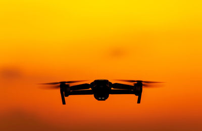 Close-up of airplane against orange sky