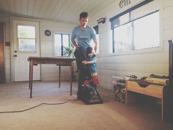 Father and girl with vacuum cleaner at home