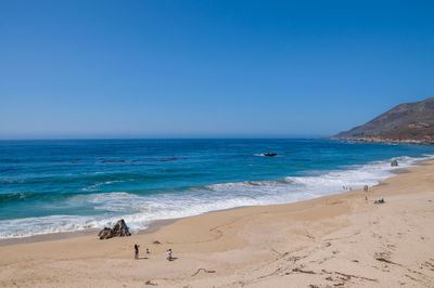 Scenic view of beach against clear blue sky