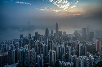 Aerial view of buildings in city at sunset