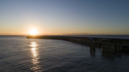 Scenic view of sea against clear sky during sunset