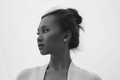 Close-up of young woman against white background