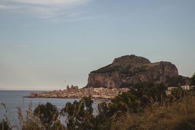 Cityscape by sea against sky