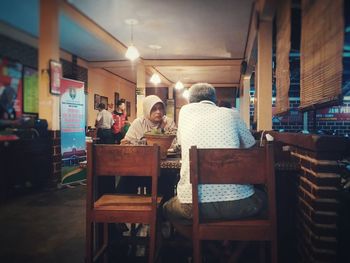 Rear view of people sitting on chair