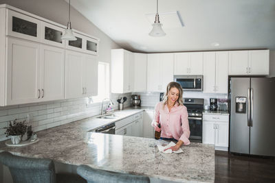 Woman cleaning kitchen counter at home