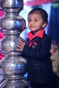 Boy standing by stacked metal containers