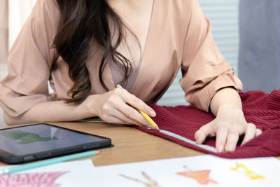 Midsection of businesswoman working on table