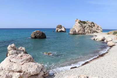 Rock formation on beach against sky