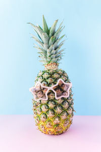 Close-up of fruit on table against blue background