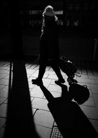 Rear view of woman walking on sidewalk