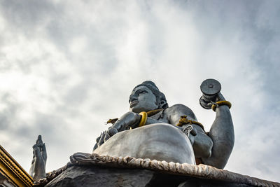 Low angle view of birds perching on statue against sky