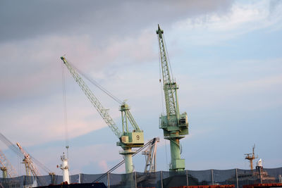 Cranes at construction site against sky