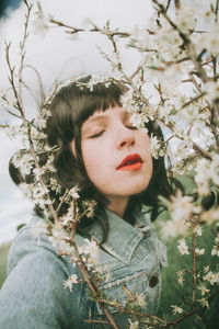 Portrait of woman with red flowers against blurred background