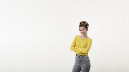Portrait of teenage girl standing against white background