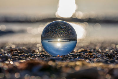 Close-up of crystal ball on beach