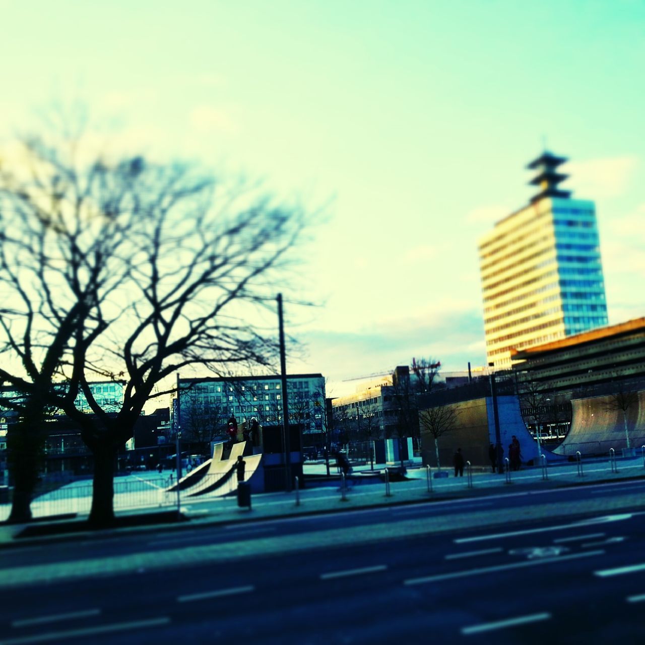 building exterior, architecture, transportation, built structure, car, land vehicle, mode of transport, city, bare tree, sky, street, tree, road, city life, building, incidental people, day, travel, city street, on the move