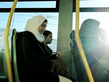 Side view of woman looking through train window