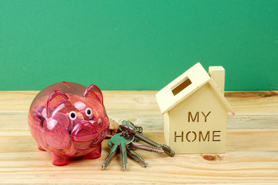 Close-up of piggy bank and keys on table