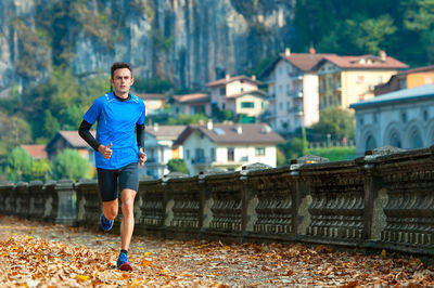 Full length of man running against buildings