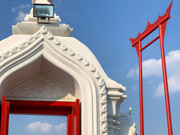 Low angle view of red bangkok giant swing against door and sky