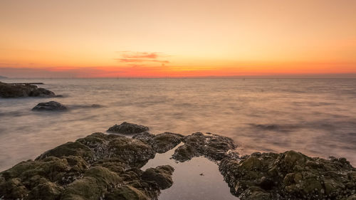 Scenic view of sea against orange sky