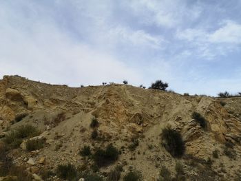 Low angle view of arid landscape against sky