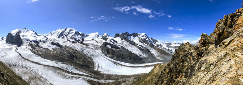 Panoramic view of snowcapped mountains against blue sky