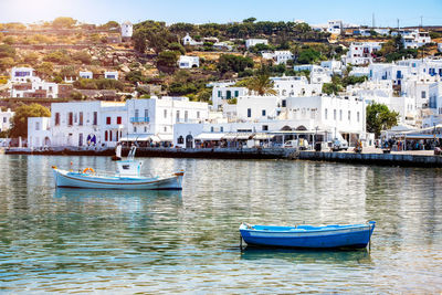 Sailboats moored in sea by town