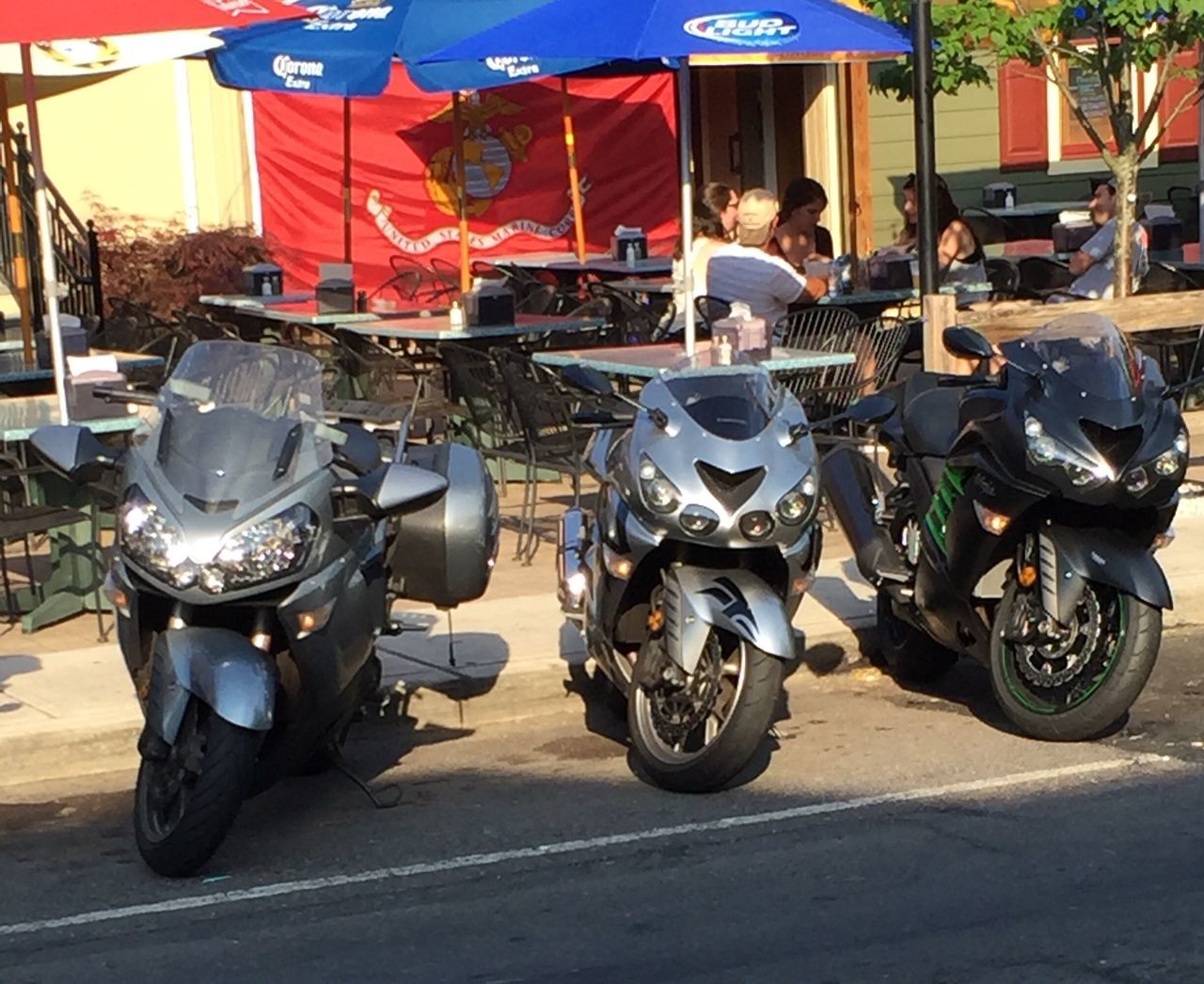 transportation, motorcycle, mode of transport, real people, land vehicle, day, men, outdoors, built structure, shadow, road, large group of people, people