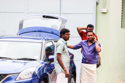 Friends standing by car