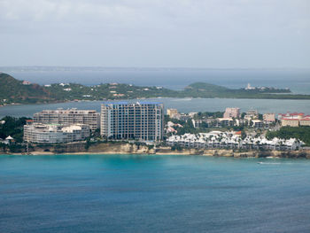 High angle view of sea by cityscape against sky