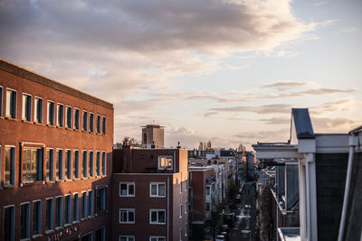 Buildings against cloudy sky at sunset