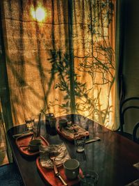 High angle view of table by curtain with shadow in restaurant