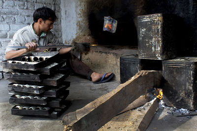 Worker casting metal in foundry