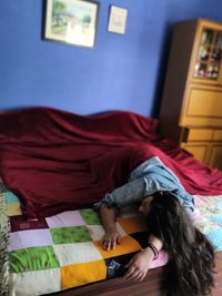 Full length of woman sleeping on bed at home