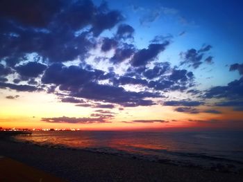 Scenic view of sea against dramatic sky during sunset