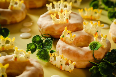 Sugar-glazed doughnuts decorated with artificial bunnies for easter 