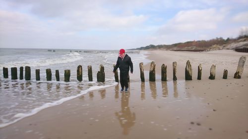 Full length of man standing on beach against sky