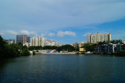 Sea by buildings against sky in city