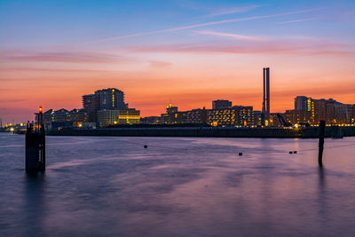 City at waterfront during sunset