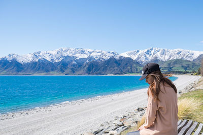 Woman sitting by lake