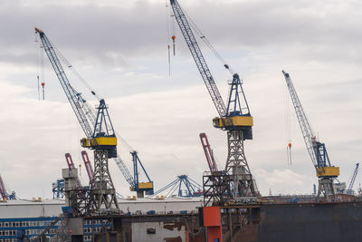 Cranes at construction site against sky