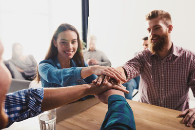 Business people stacking hands at office