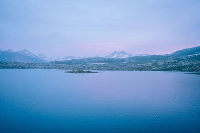 Scenic view of sea by mountains against sky