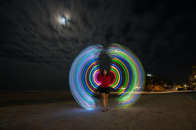 Illuminated light painting against sky at night