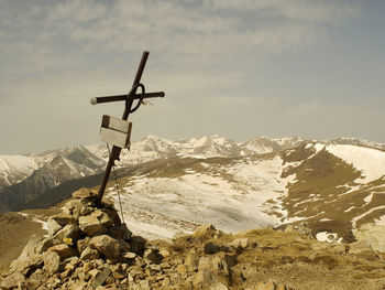 Windmill on snowcapped mountain against sky