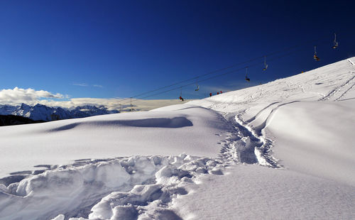 Low angle view of ski lift against snowcapped mountain