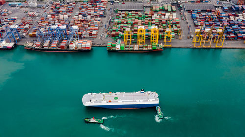  tugboat dragging large roro roll on off into commercial dock import and export 