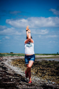 Woman standing on one leg outdoors