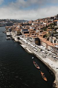 High angle view of townscape by river against sky